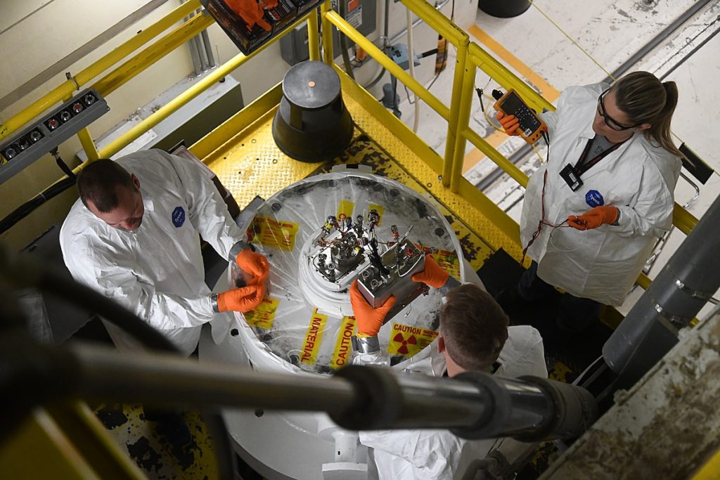 three nuclear workers assembling a device
