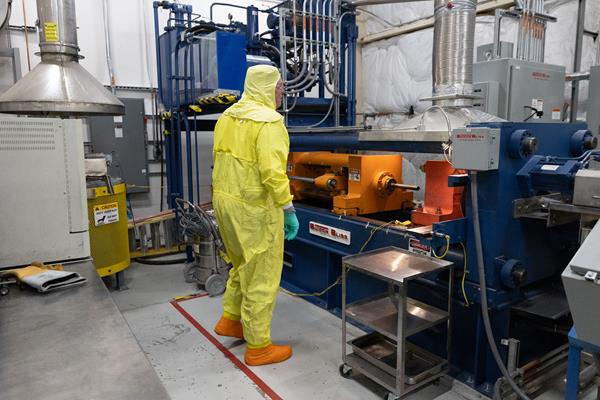 person in a hazard suit observing nuclear materials
